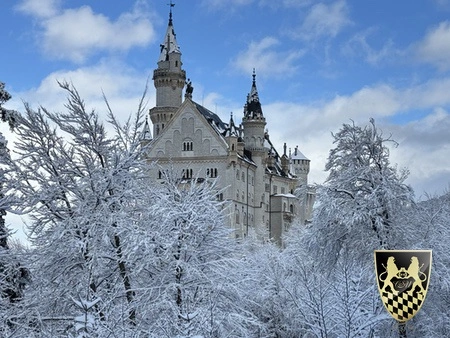 A snow-covered Neuschwanstein Castle stands majestically amidst evergreen trees, capturing the enchanting beauty of winter in Bavaria. This iconic castle, often referred to as "Sleeping Beauty's Castle," is a popular destination for those on a Neuschwanstein Castle tour from Munich.