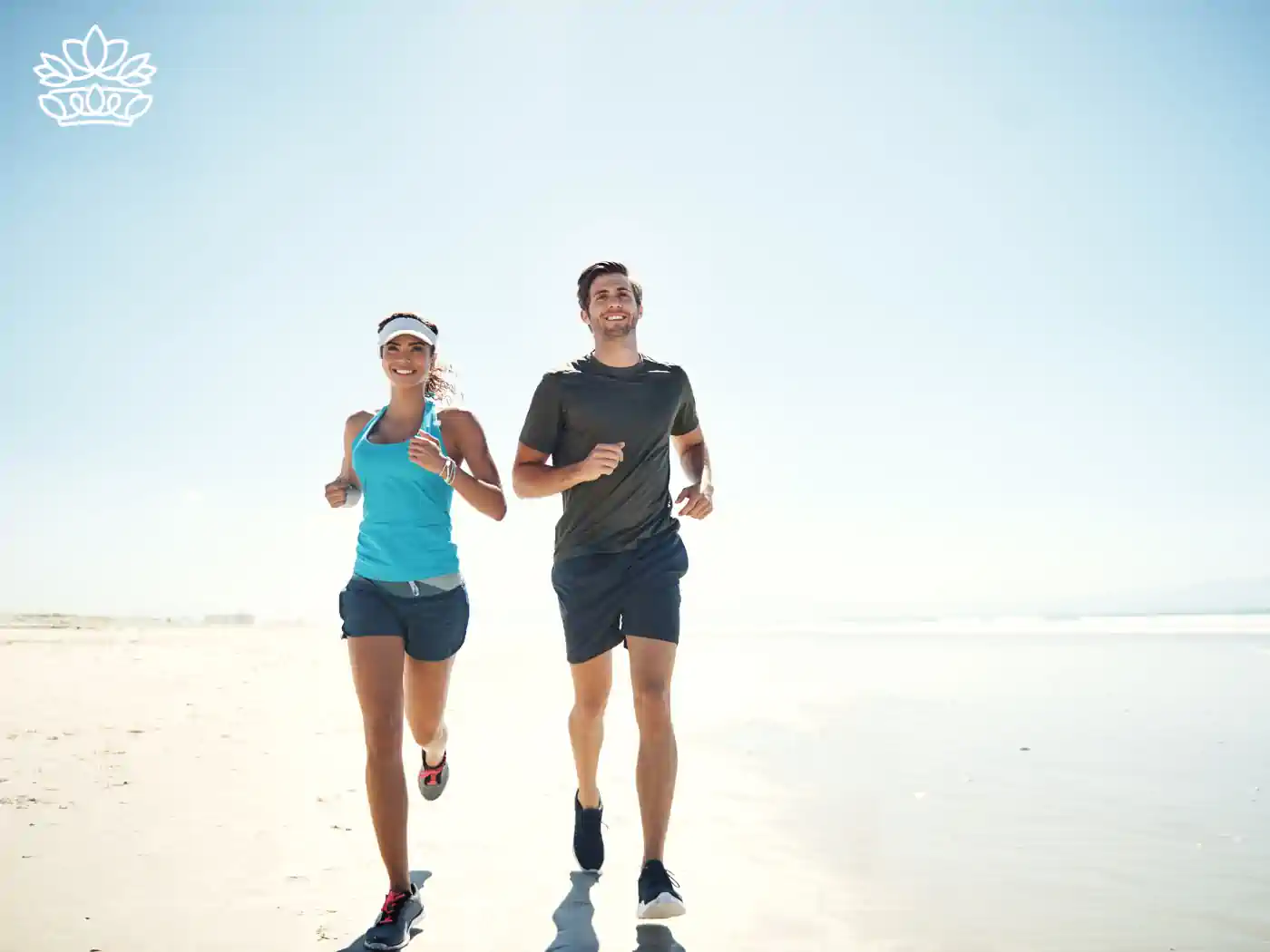 A couple jogging on a sunny beach, symbolizing fitness and wellbeing. Fabulous Flowers and Gifts - Health and Wellbeing Collection.