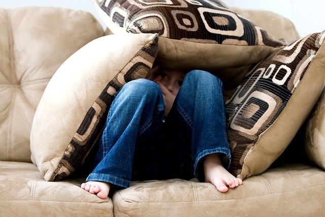 child on microfiber couch with pillows
