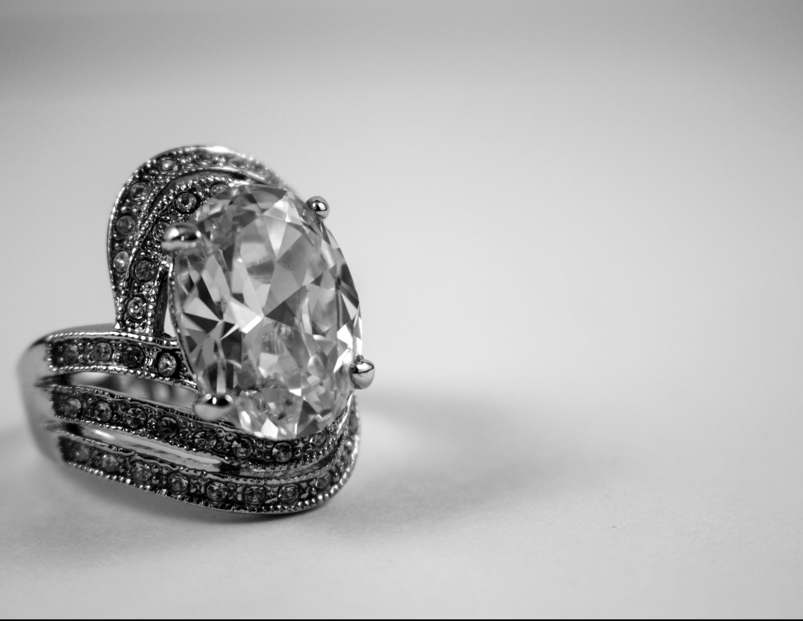 A close-up of a large, dark grey platinum ring with a diamond.