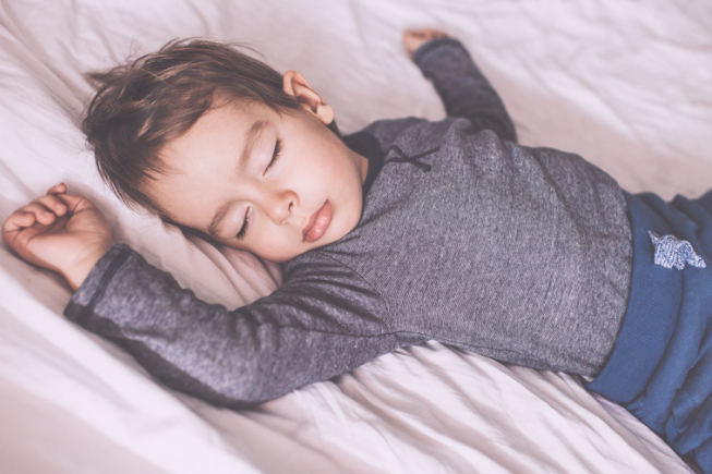 Toddler sleeping with arms outstretched