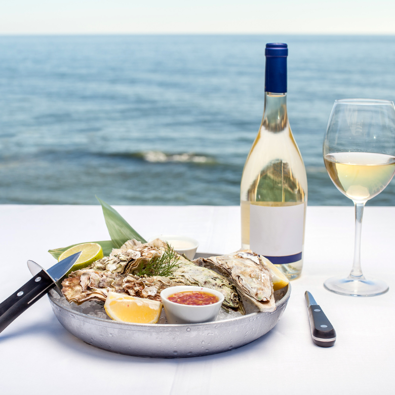 Image displaying oysters paired with white wine and butter sauce.