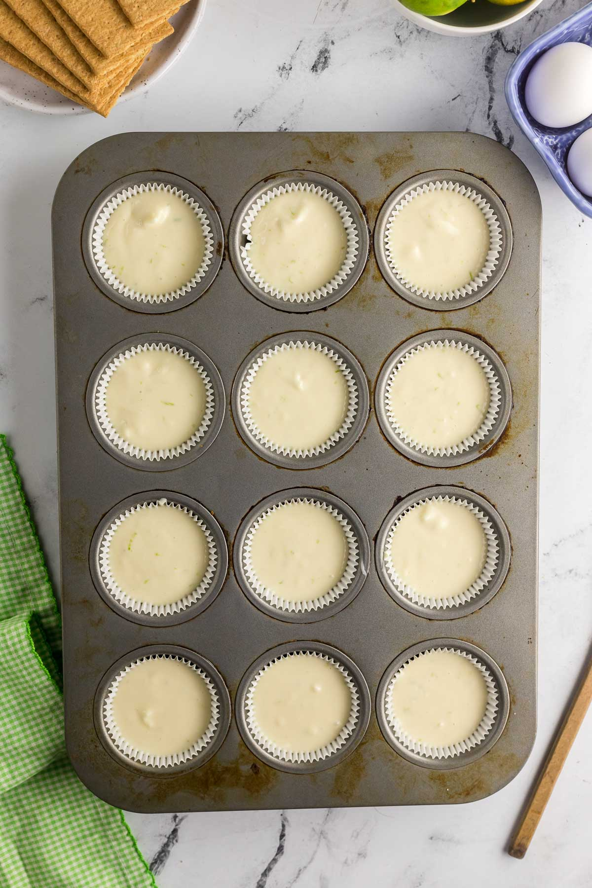 unbaked mini key lime cheesecakes in muffin tin
