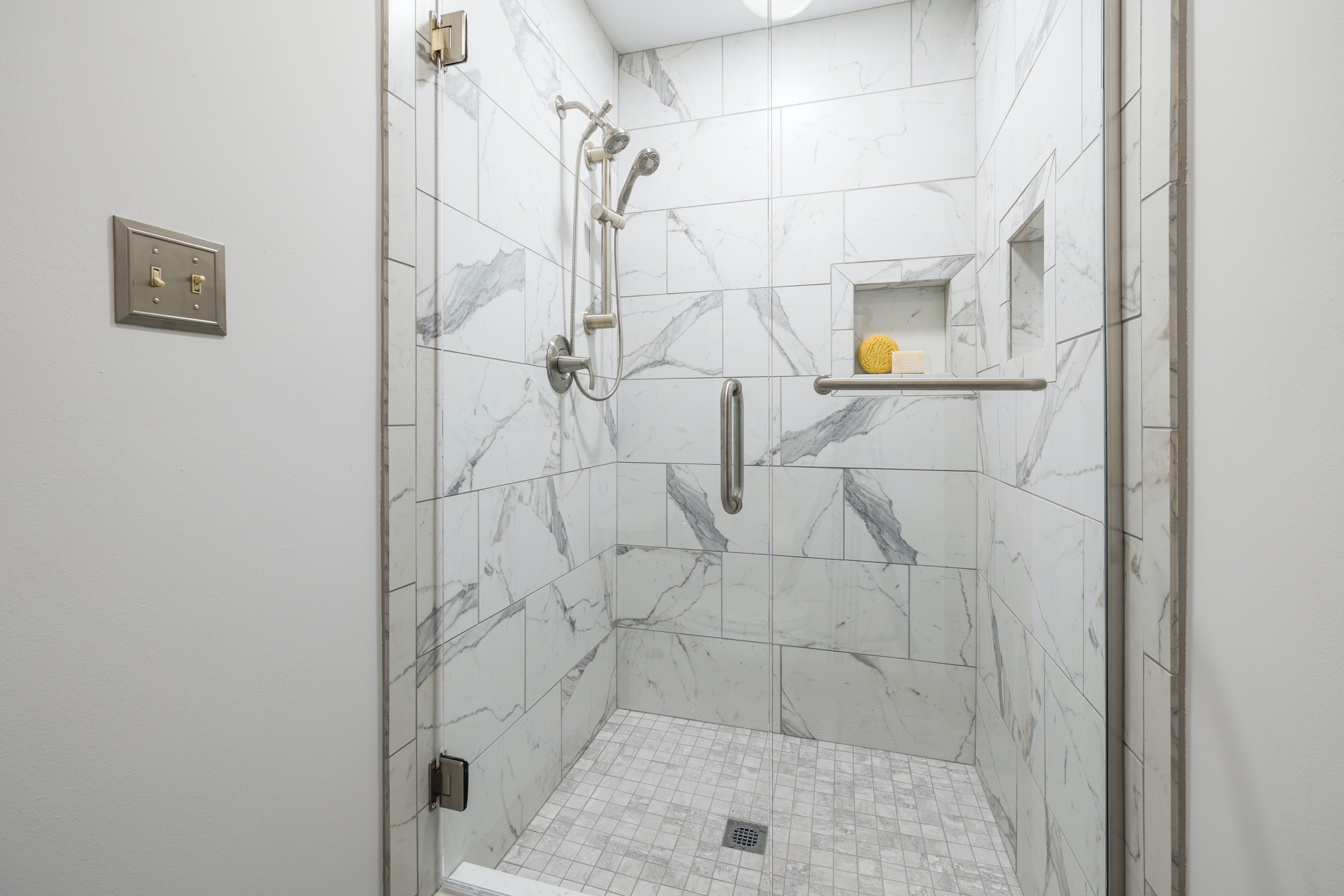 white marble shower with niche shelving