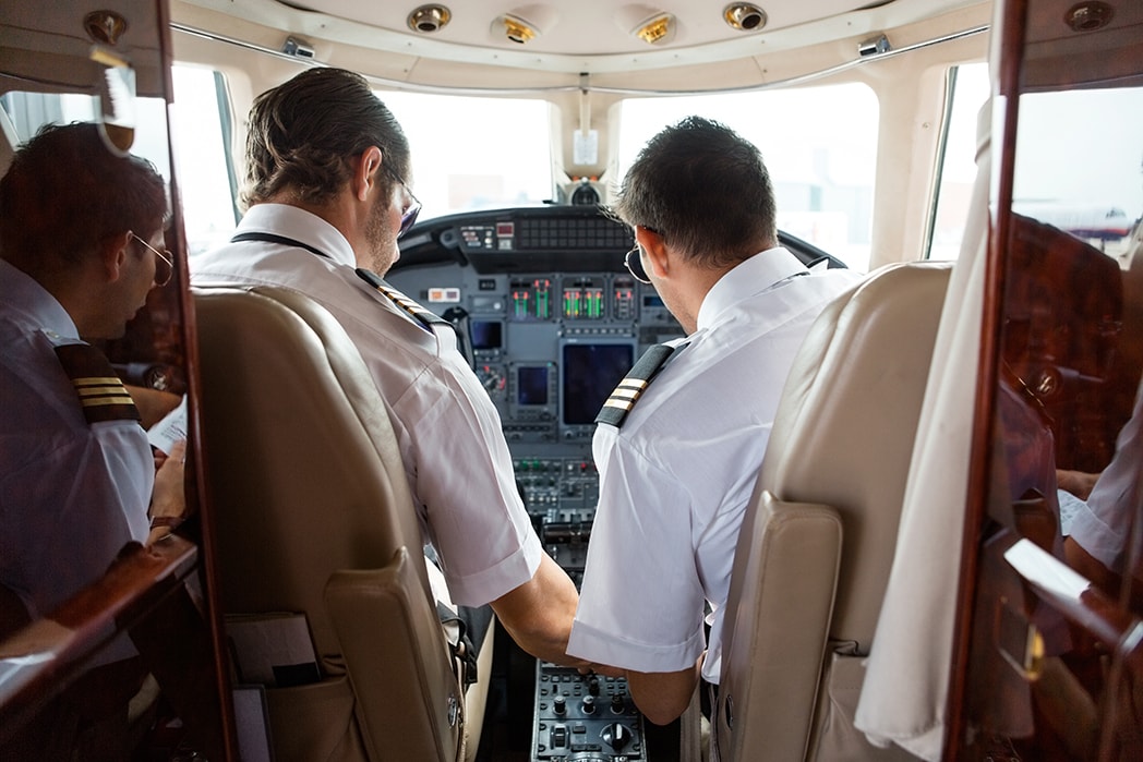 A flight instructor demonstrating aircraft controls to a student pilot.