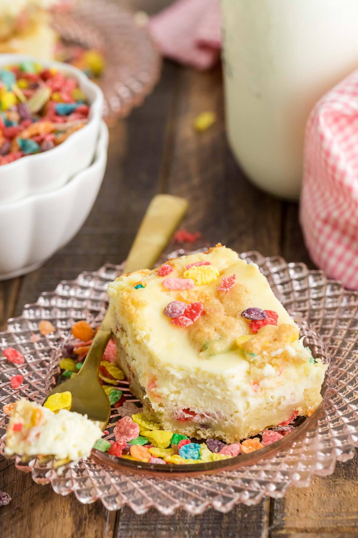 fruity pebble cheesecake bar on a plate with a fork