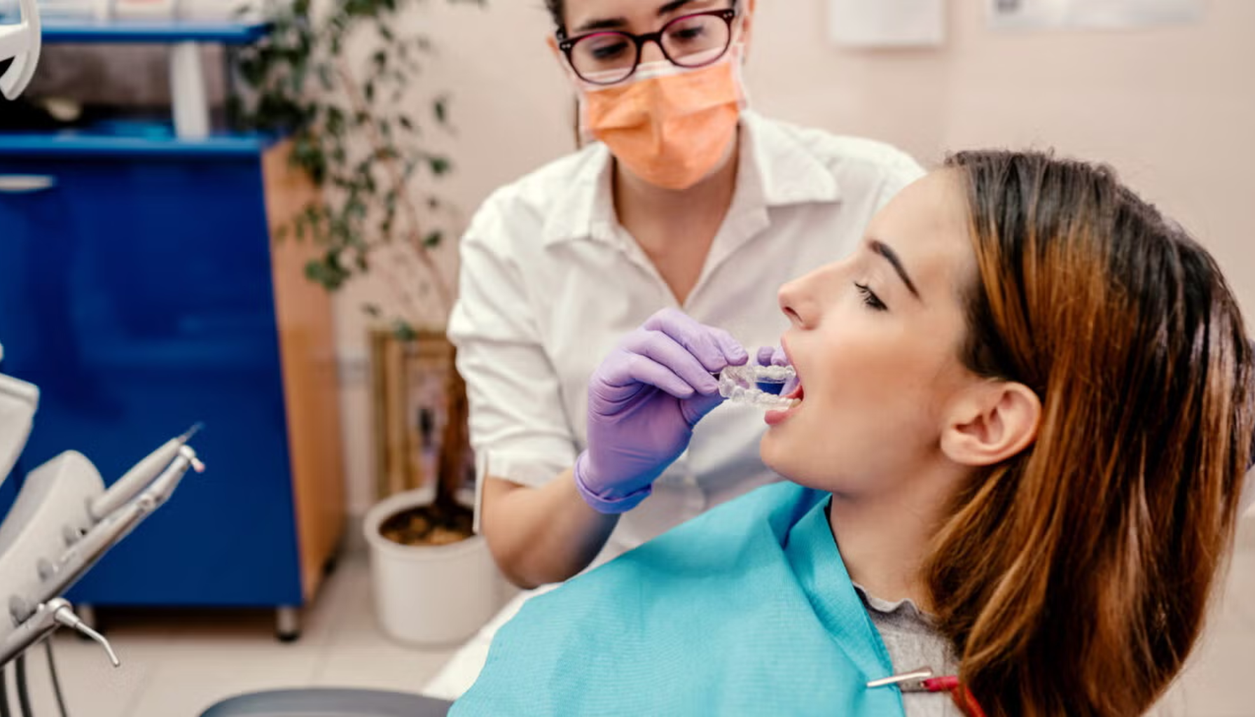 Tannlege tar tannavtrykk i pasientens munn under behandling i tannklinikk med beskyttelsesutstyr.