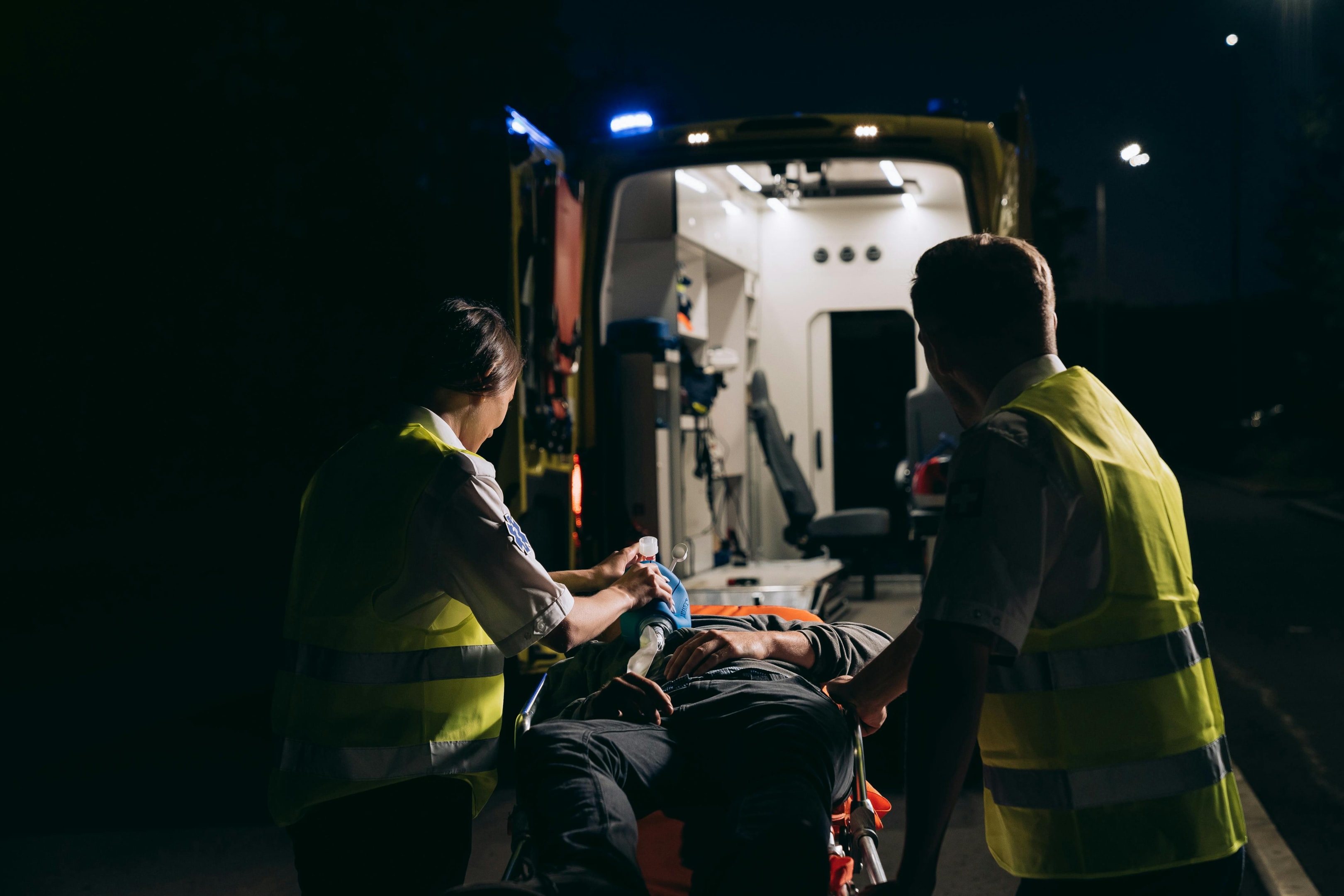 Paramedics carrying an injured person on a gurney.