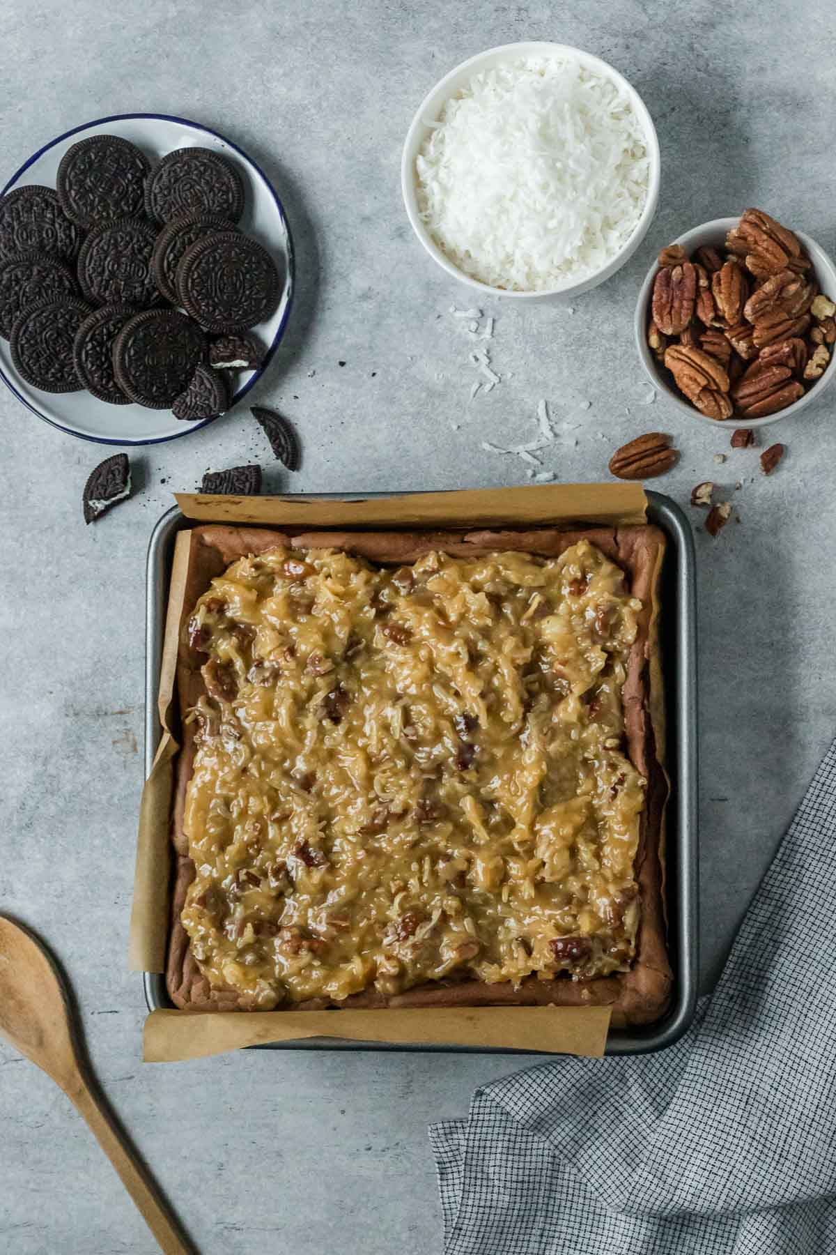 coconut pecan topping spread on top of chocolate cheesecake bars