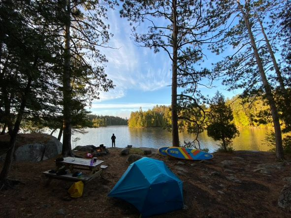 inflatable paddle boards by a tent