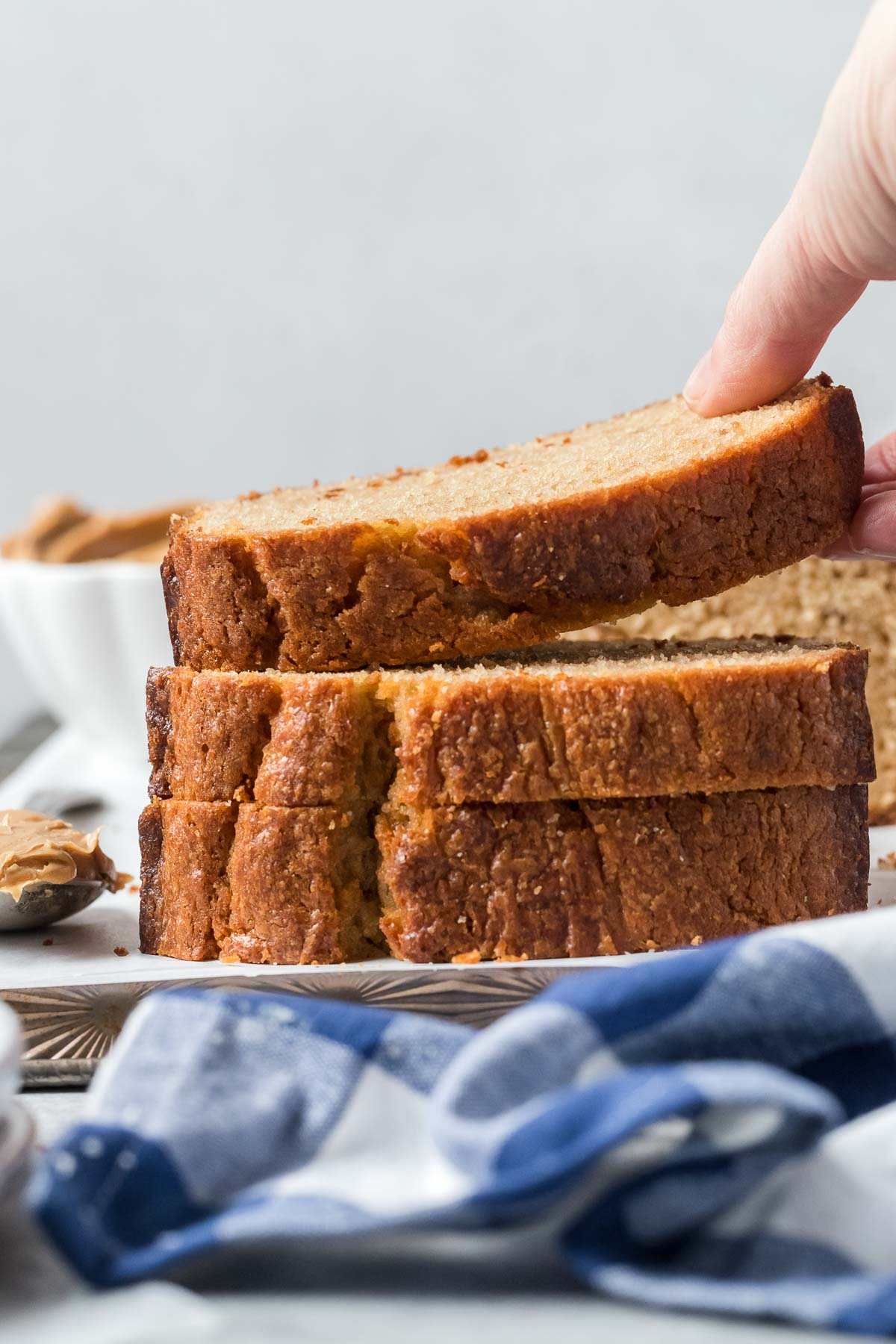 hand taking a slice of peanut butter bread from a stack