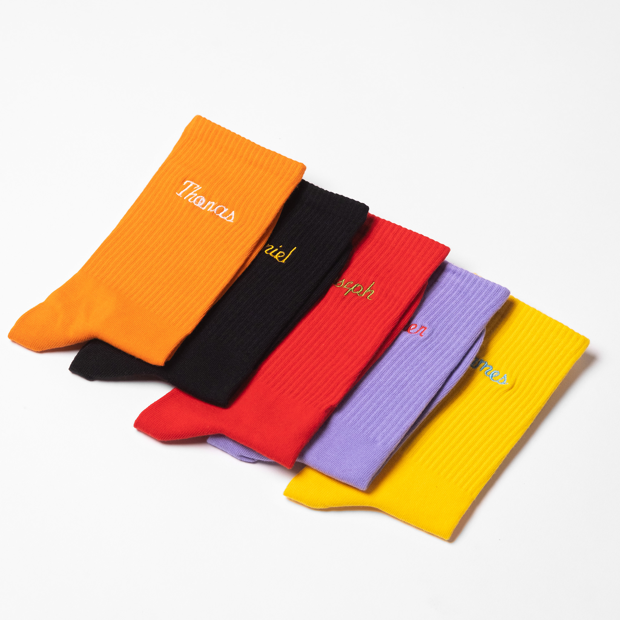 A collection of mens customised crew socks with male names embroidered onto each pair.
