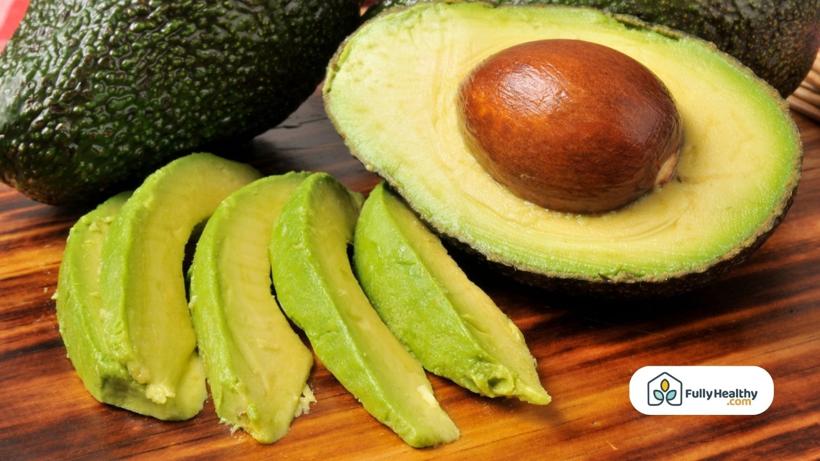 Sliced avocado on wooden board showing bright green fresh texture