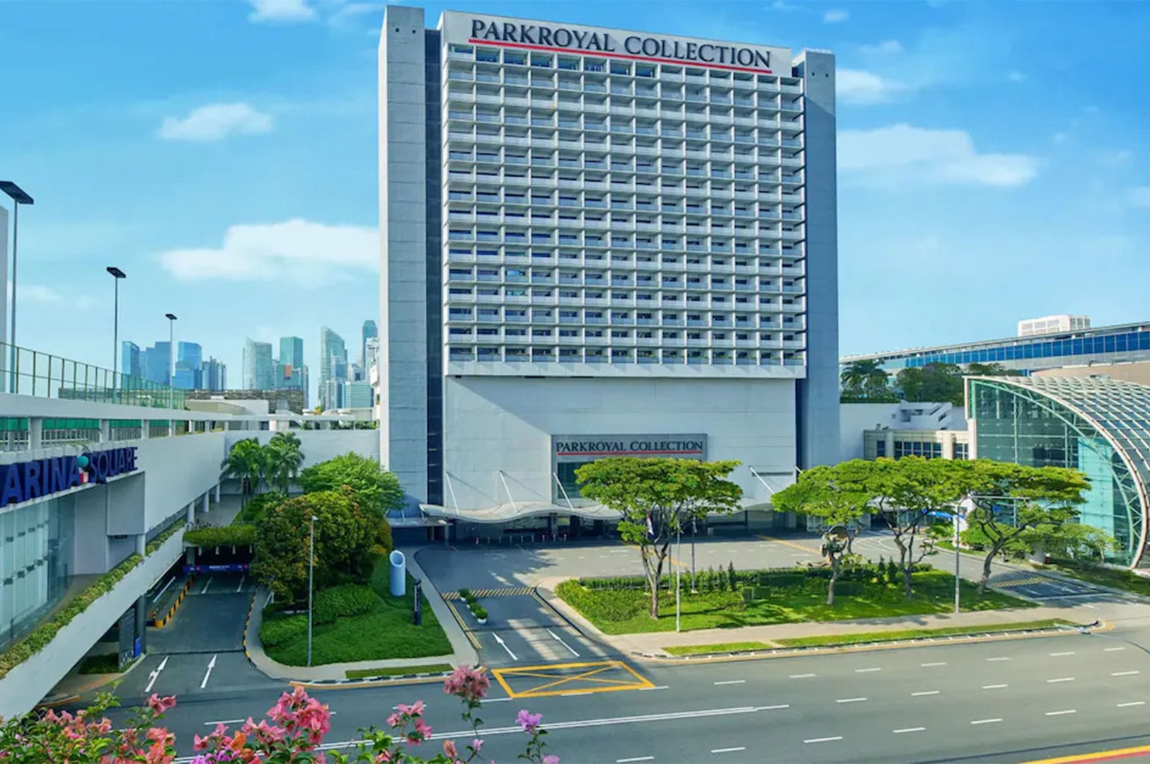 Front view of Parkroyal Collection Marina Bay, a modern high-rise beside Marina Square with city skyline in the background.