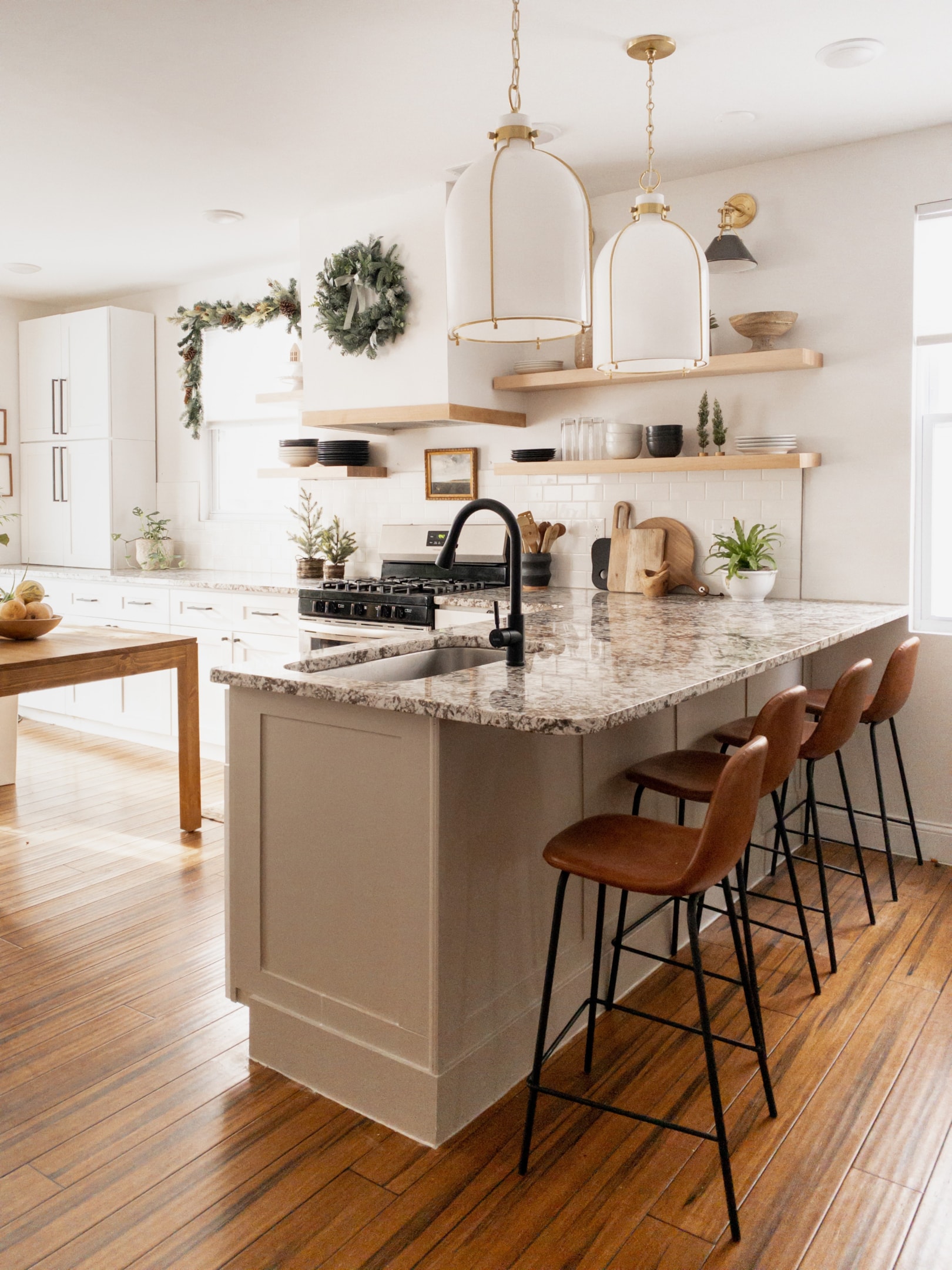 Cozy kitchen with wood accents, mustard cabinets, and clear glass pendant lights over the island, creating a rustic and welcoming atmosphere.