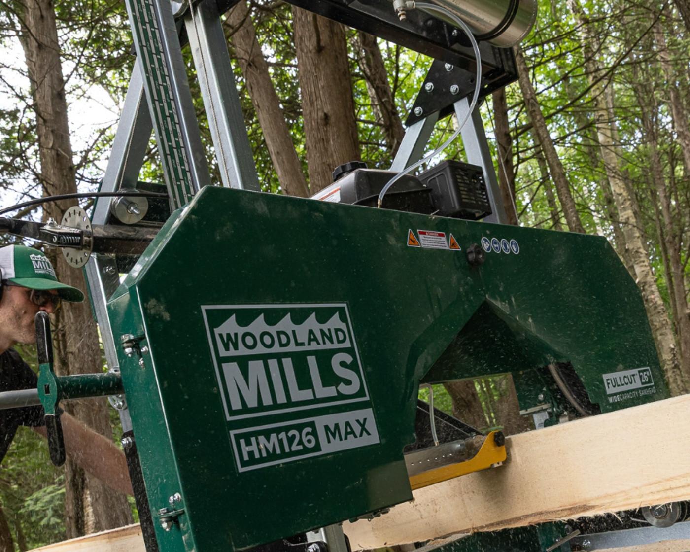 The Woodland Mills HM126MAX Portable Sawmill cutting into a log.