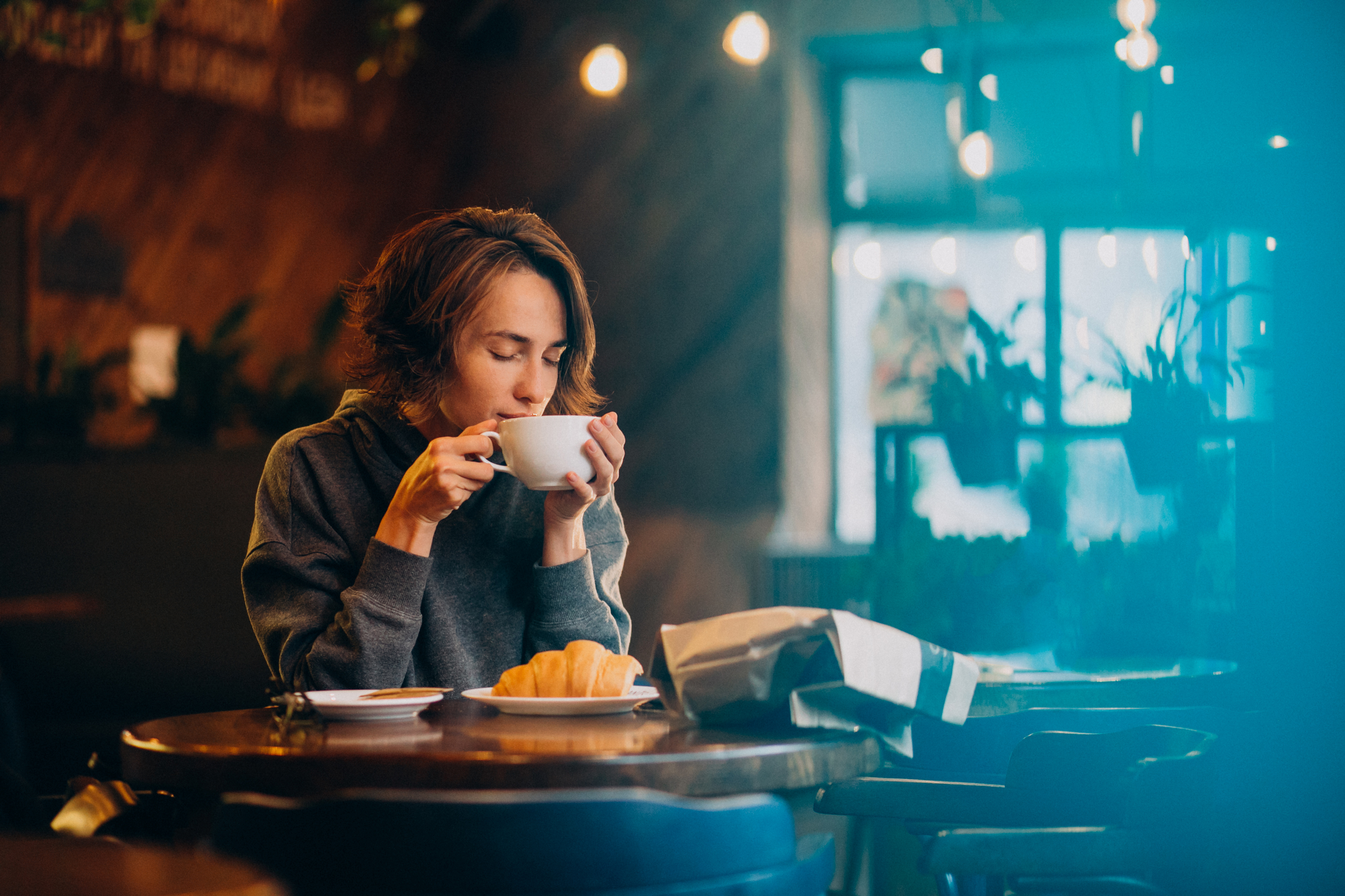 Mulher jovem tomando café com mel. Foto: Freepik