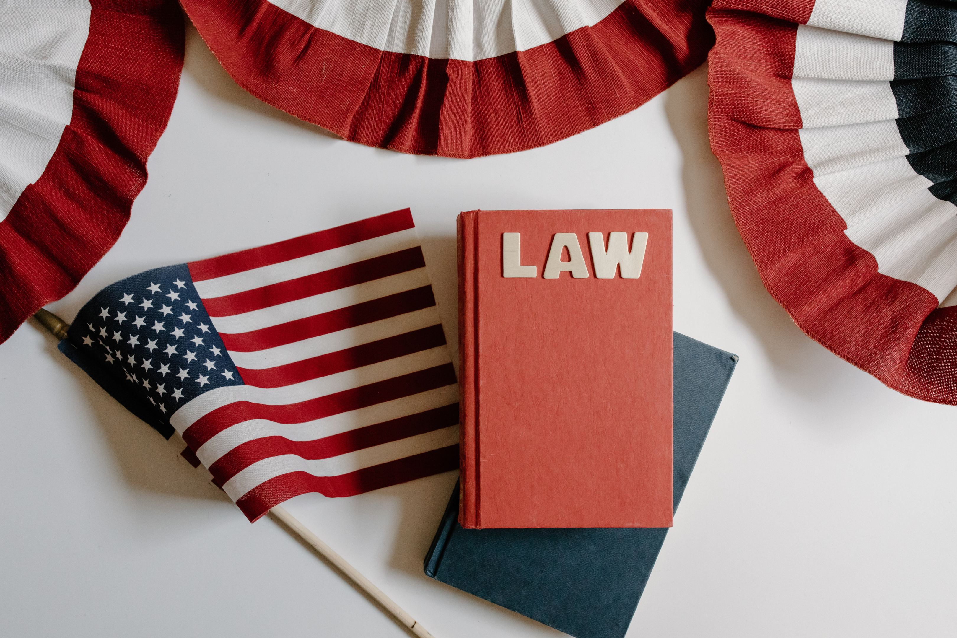US flag, a red book with text that reads "law" and 4th of July buntings on white background