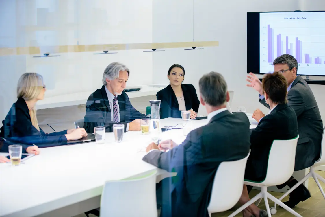Business owner and broker reviewing financial documents and market data during a professional valuation meeting.