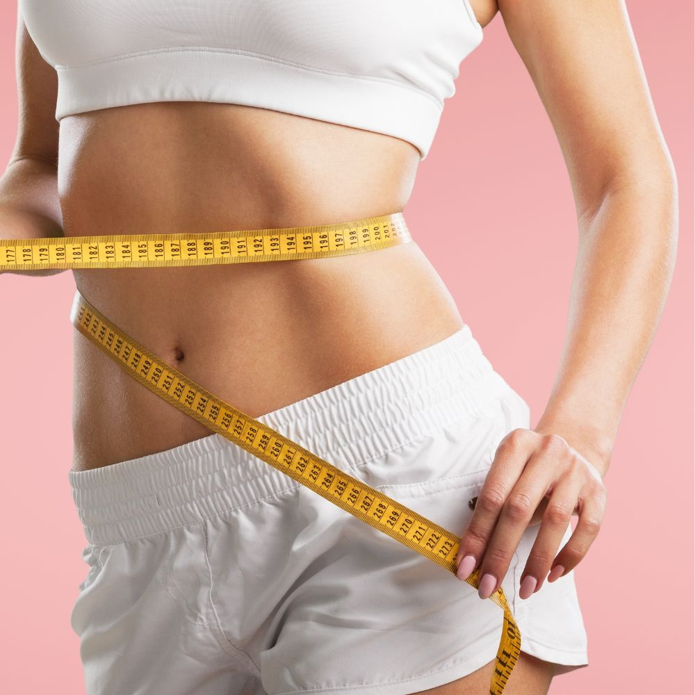 A person measuring their body weight reduction after successful weight loss journey with a scale and a tape measure