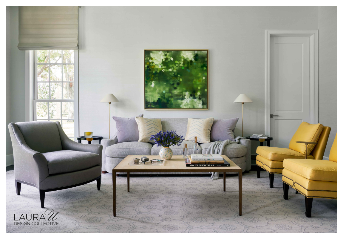 Formal sitting room with Phillip Jeffries Glam Grass wallcovering, pale sofa, gray lounge chairs, mustard accent chairs, brass floor lamps, and green abstract artwork.