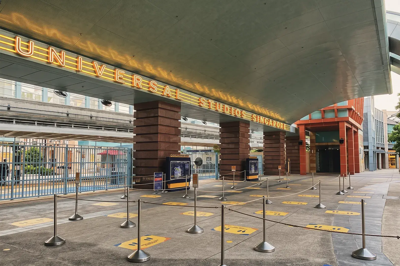 Entrance to Universal Studios Singapore featuring illuminated signage, queue lines, and modern architecture at Resorts World Sentosa.