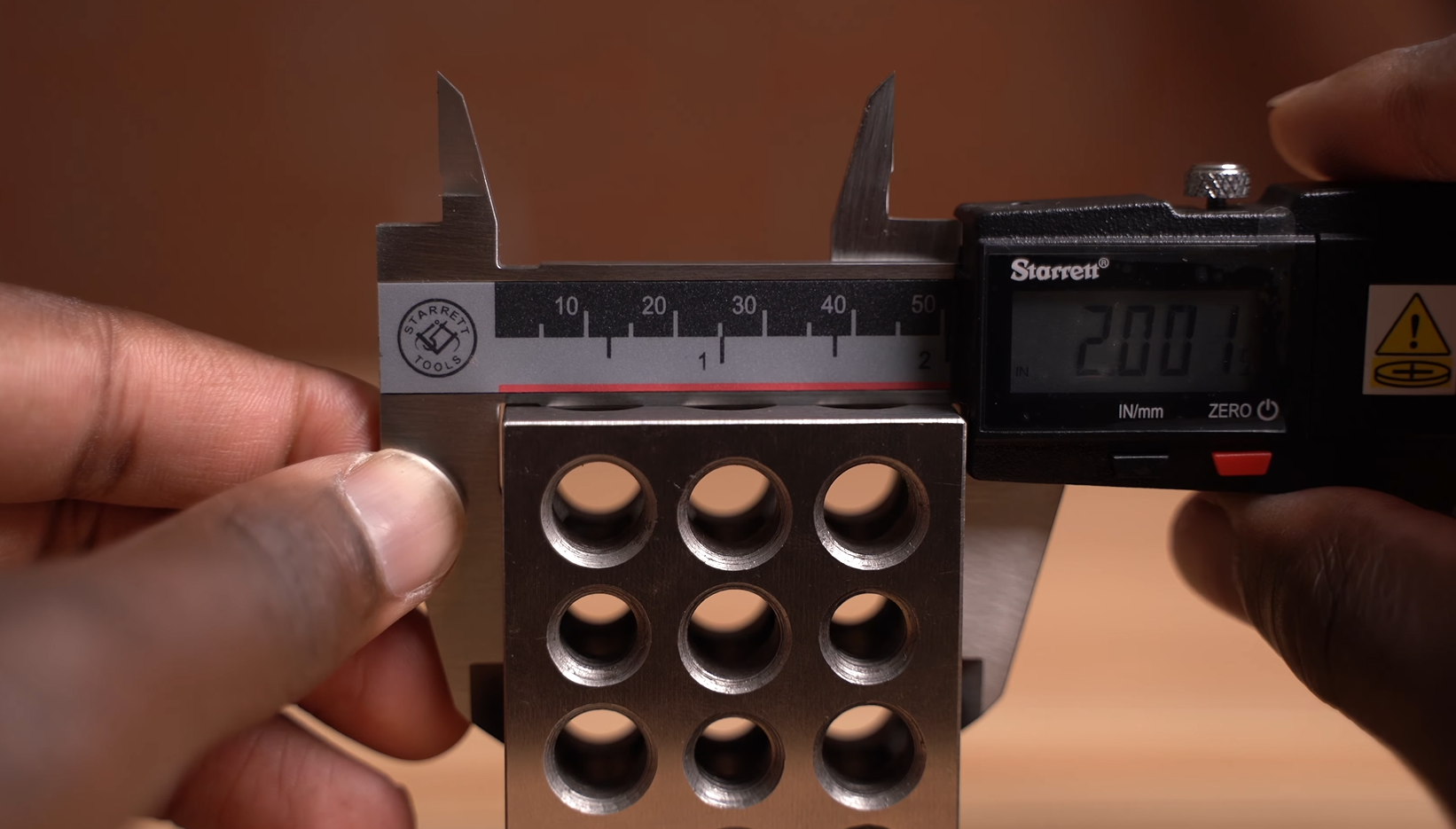 using Starrett caliper to measure the outside of a 2 inch block