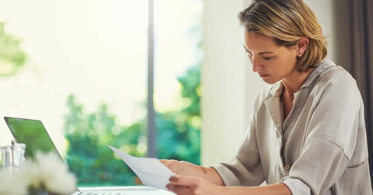 Woman preparing an IRS collection information statement with pay stubs and bank statements.