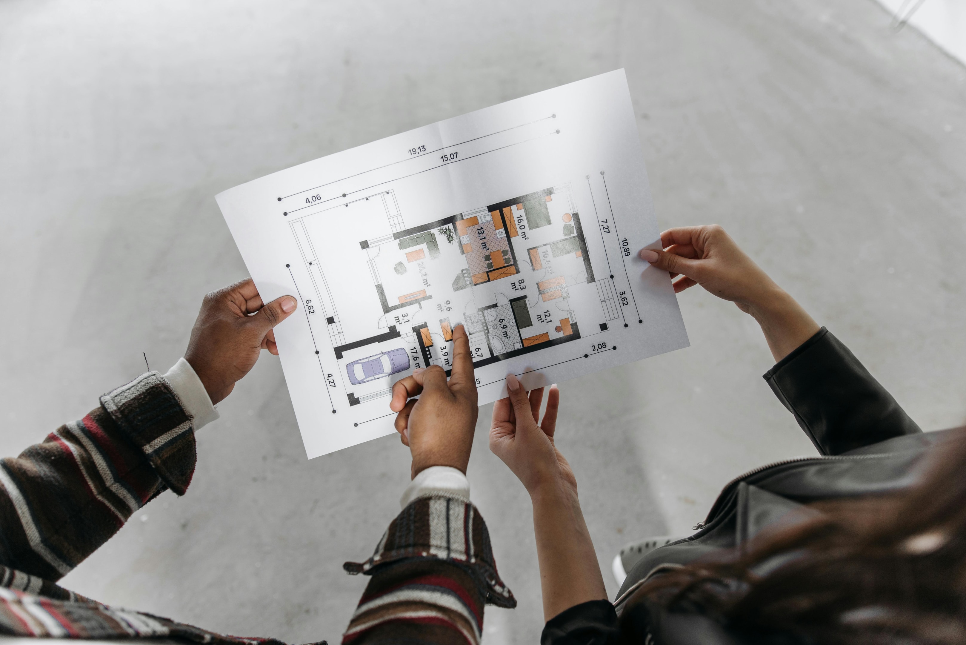 Real estate investors looking over floorplan of home. 