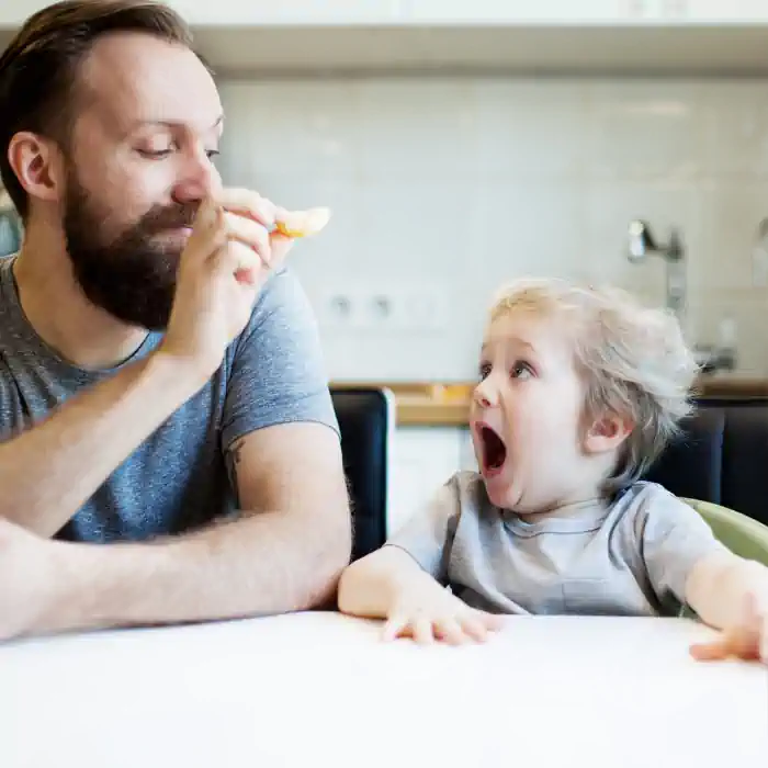 Father playfully feeding his excited child, illustrating the benefits of the CHINAHERB Supplement Collection, which uses herbs to give phases of health improvement and create suction for better absorption, available at The Good Stuff Health Shop South Africa