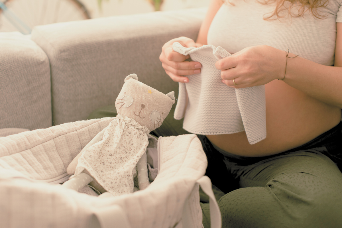 Pregnant women packing a bag and folding baby clothes