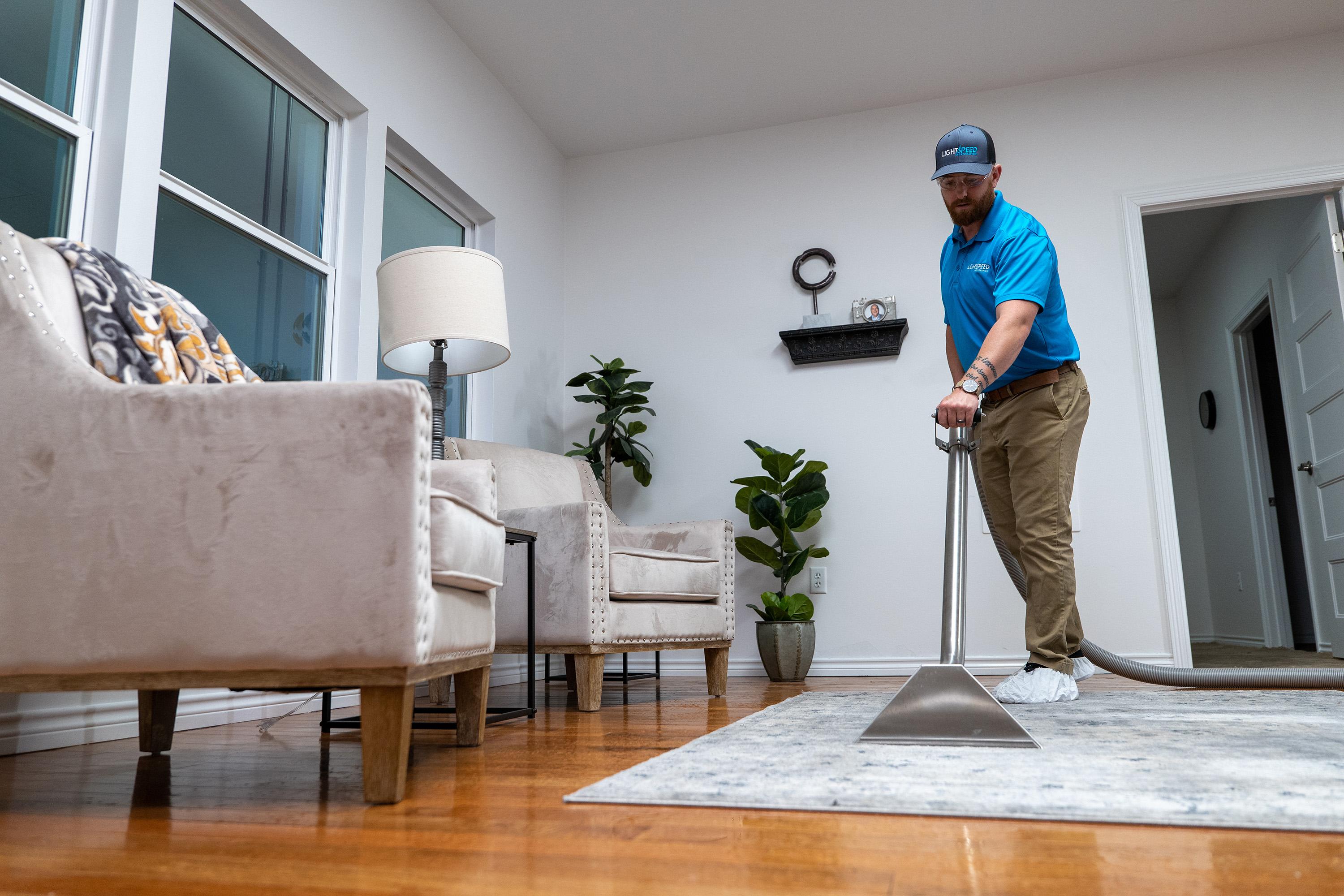 The image shows professional water extraction equipment actively removing standing water from a residential floor, highlighting the importance of addressing water damage to prevent mold growth and further structural damage. This process is crucial for ensuring proper drying of affected materials and maintaining the structural integrity of the building.