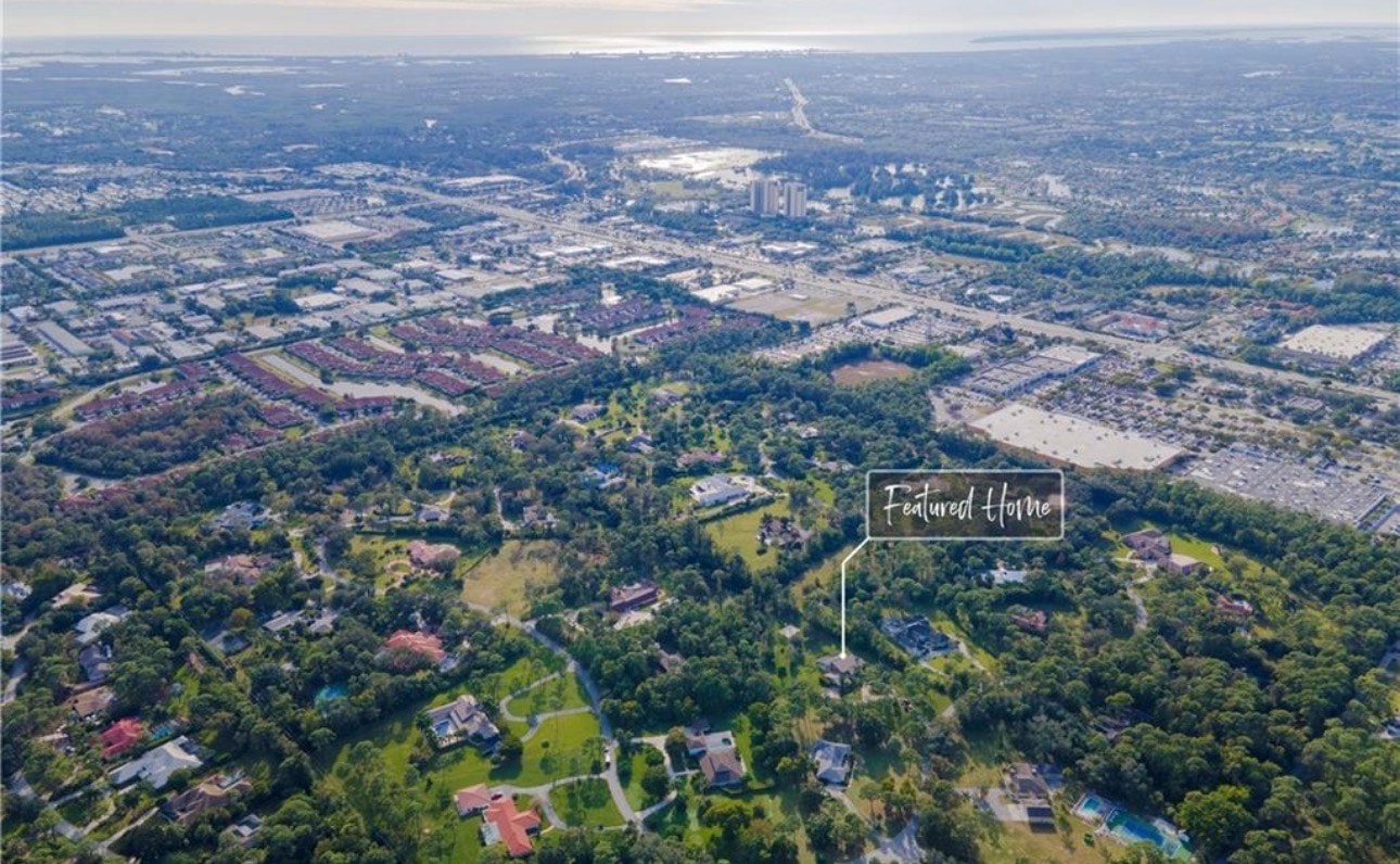 The image depicts an elegant gated entrance to a neighborhood in Fort Myers, featuring lush landscaping and a security gate that ensures maximum privacy for residents. The serene surroundings include mature vegetation, highlighting the charm of Brynwood properties and the inviting atmosphere of this upscale community.