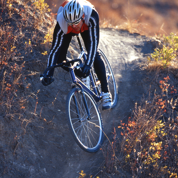 An image showing a cyclocross race with riders navigating obstacles on mixed terrain.