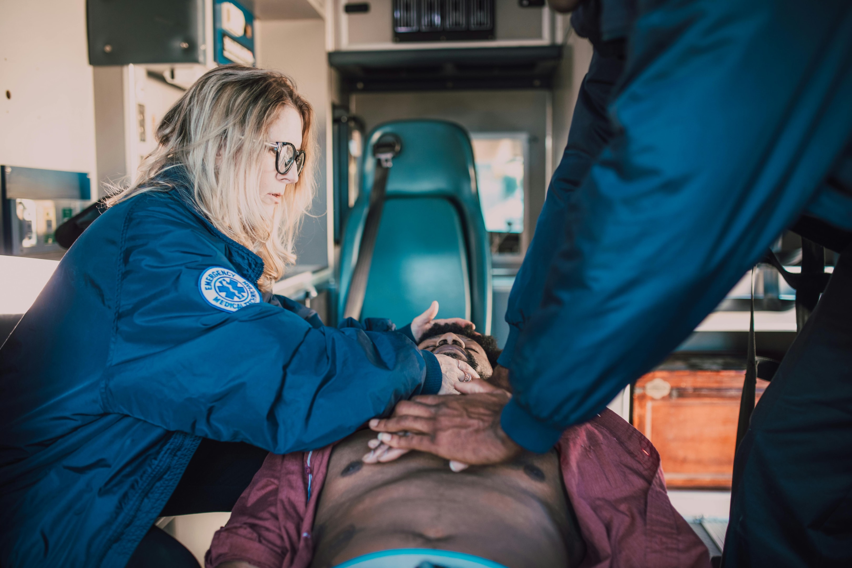Paramedics assessing an unresponsive individual, indicating the need for CPR.