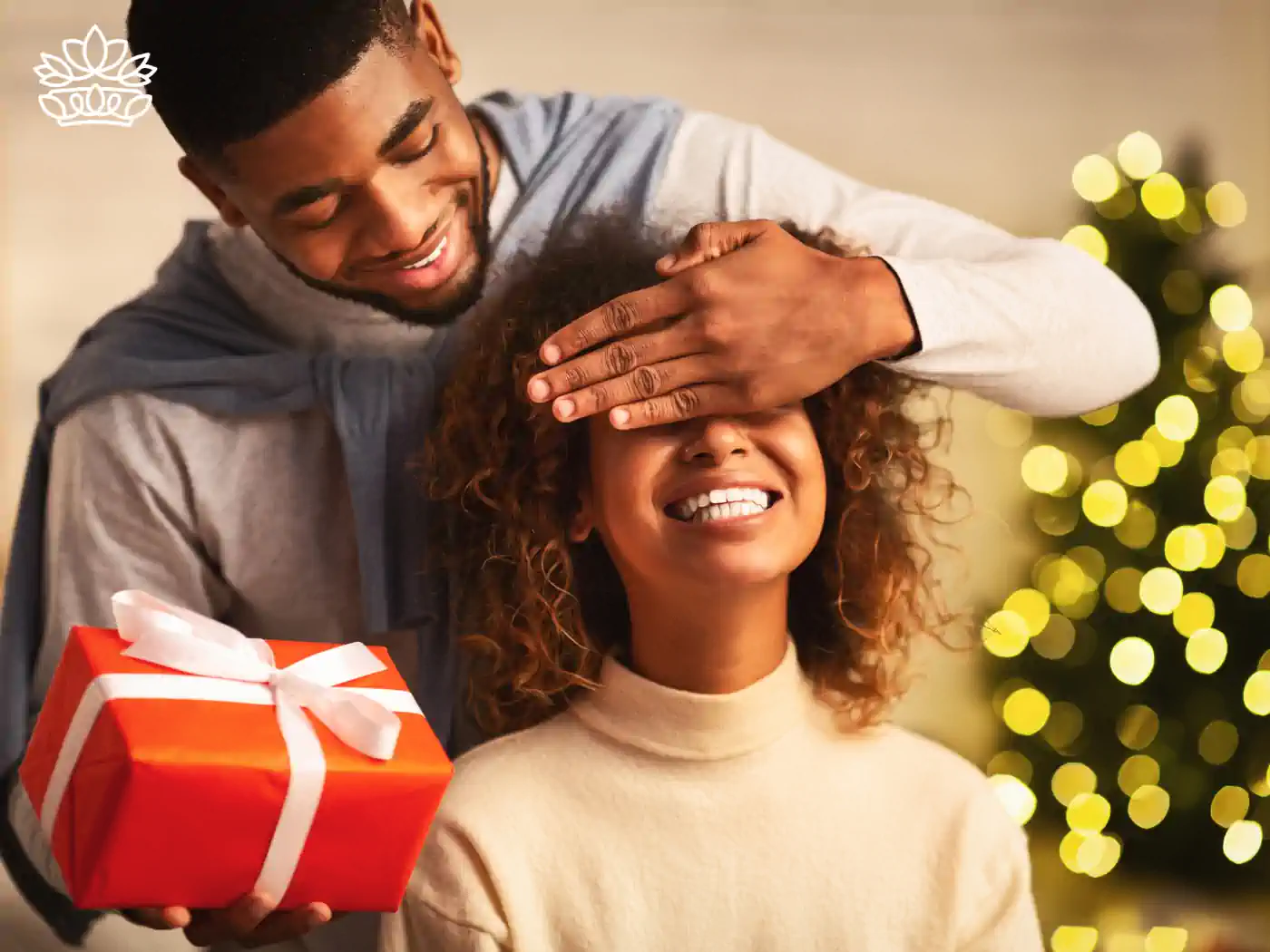 A man presenting a gift box to his smiling partner during the holiday season - Fabulous Flowers and Gifts - Nationwide Gift Box Delivery