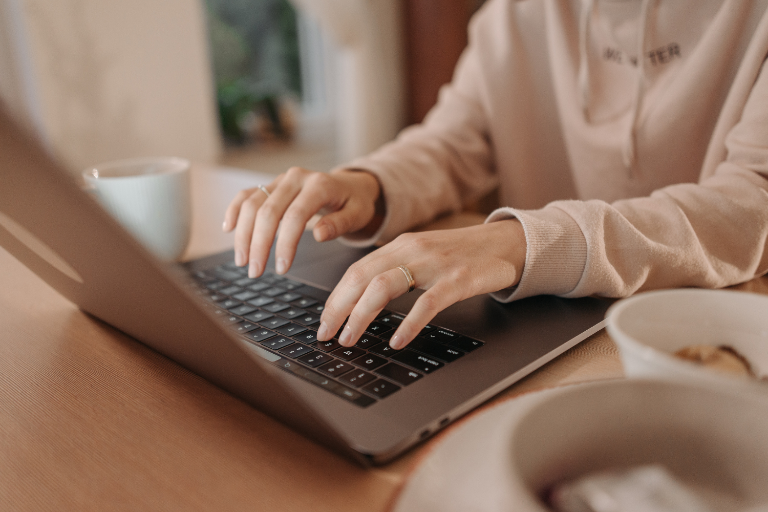 A pair of hands typing on their laptop.
