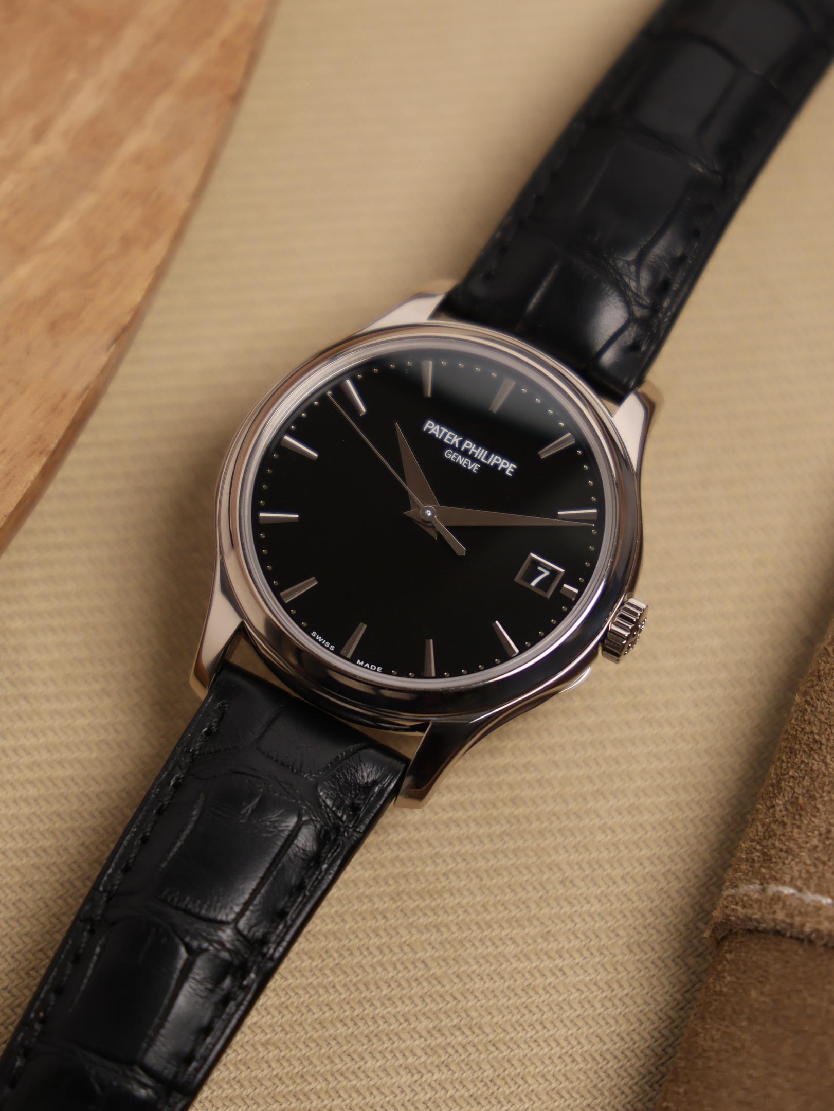 A close-up view of an elegant gold dress watch featuring a dark leather strap, set against a neutral background, highlighting the intricate design and craftsmanship often associated with Patek Philippe timepieces. The watch embodies sophistication and style, perfect for any formal occasion.