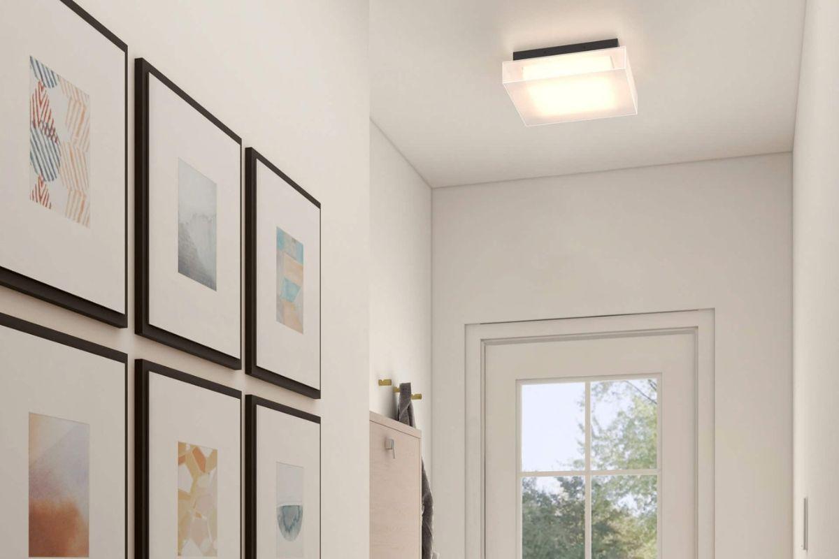 Square flush mount ceiling light with clear glass shade in a bright white hallway