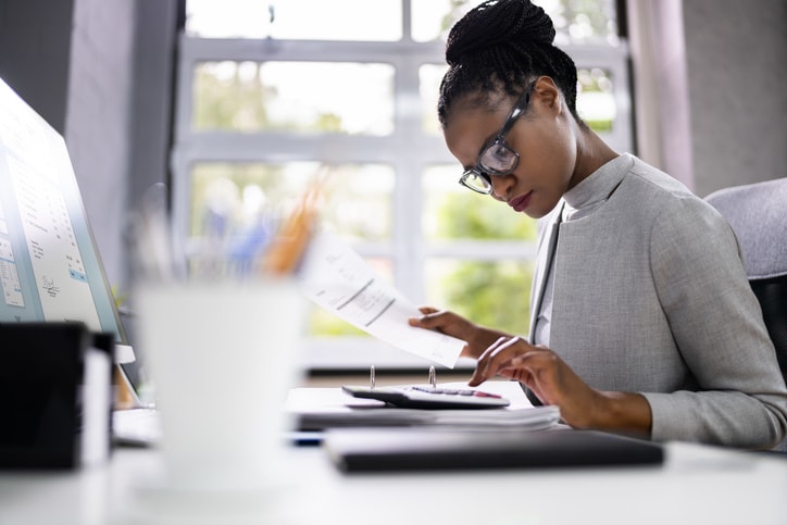 Accountant on a calculator looking at net financial debt