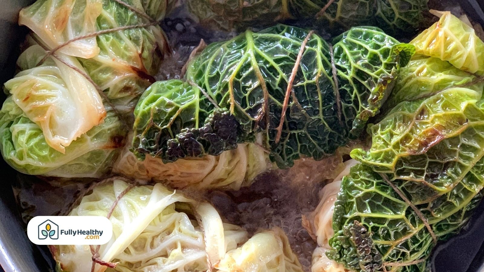 Stuffed cabbage rolls simmering in pot with sauce