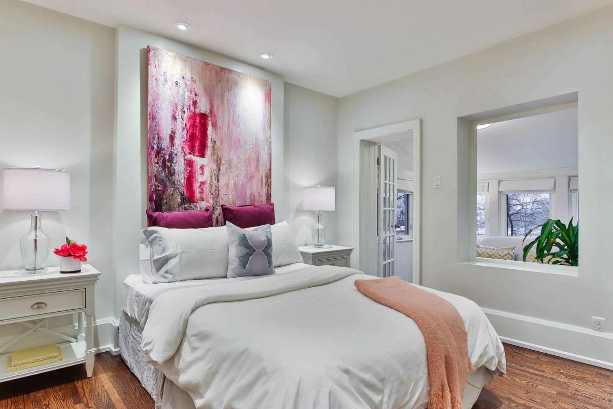 Bright bedroom with recessed ceiling lighting, bedside lamps and contemporary white furnishings