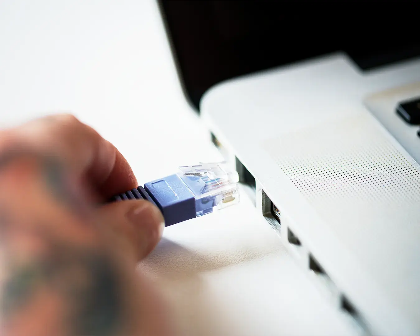 Close-up of a traditional POS system with a hand connecting a cable for business payment processing