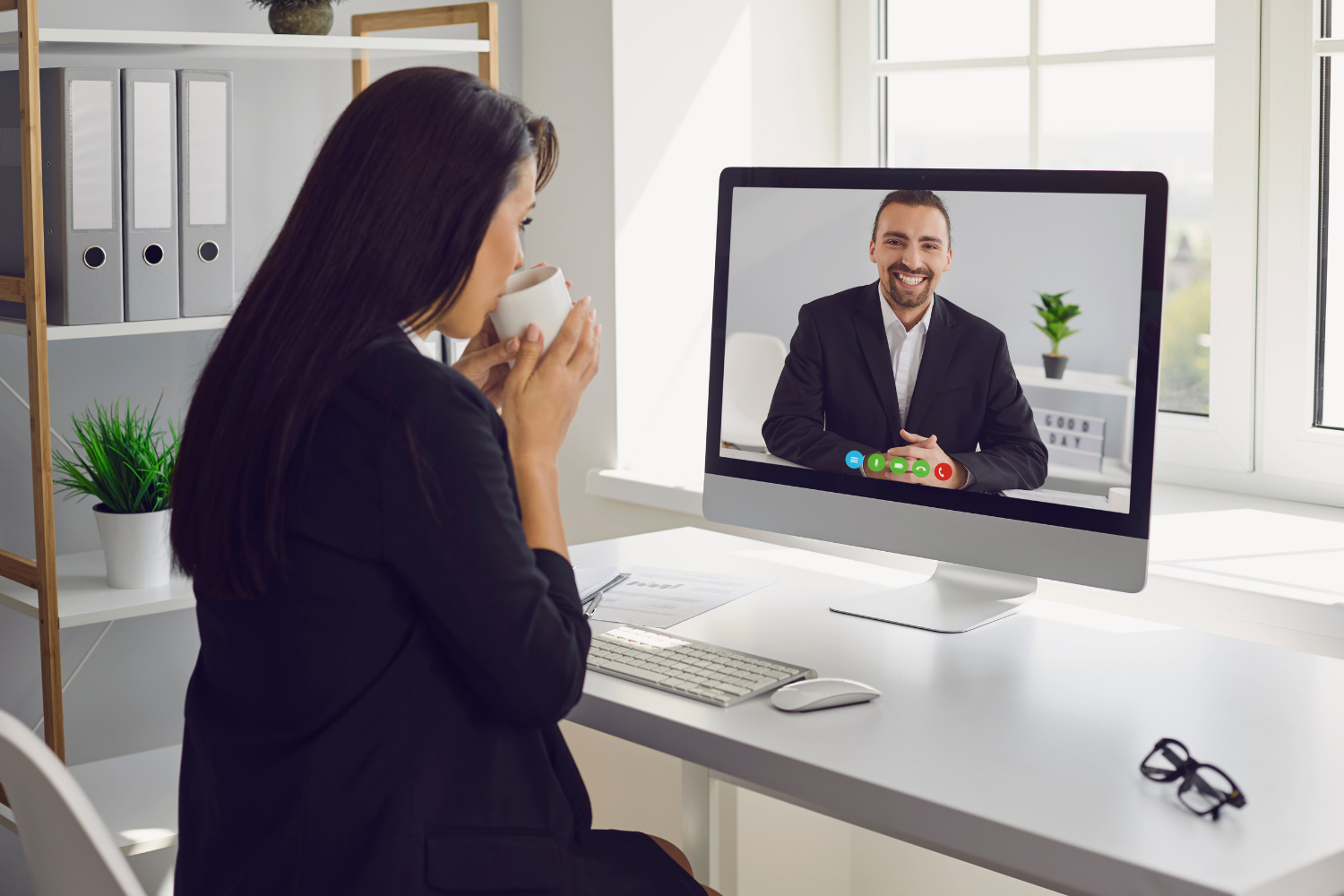 U.S. manager smiling in a video call with a virtual assistant.