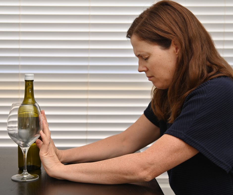 A person looking away from a glass of beer, symbolizing the financial and lifestyle benefits of quitting alcohol