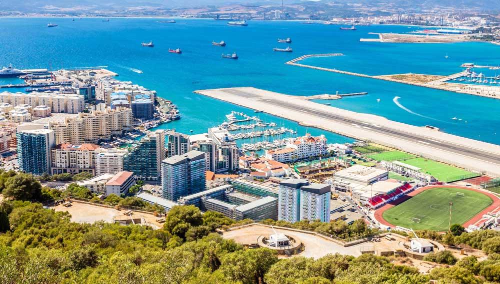 UK nationals relocating to Gibraltar from the UK viewing Gibraltar Airport and marina during residency planning.