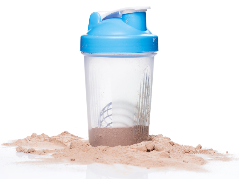 A picture of a shaker cup sitting in protein powder.