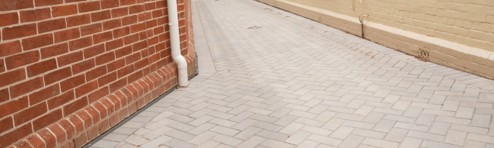 An image showing the intricate pattern of herringbone paving, which is a popular type of interlocking brick pavement used for driveways and walkways. This image helps to illustrate what is herringbone paving and its benefits.