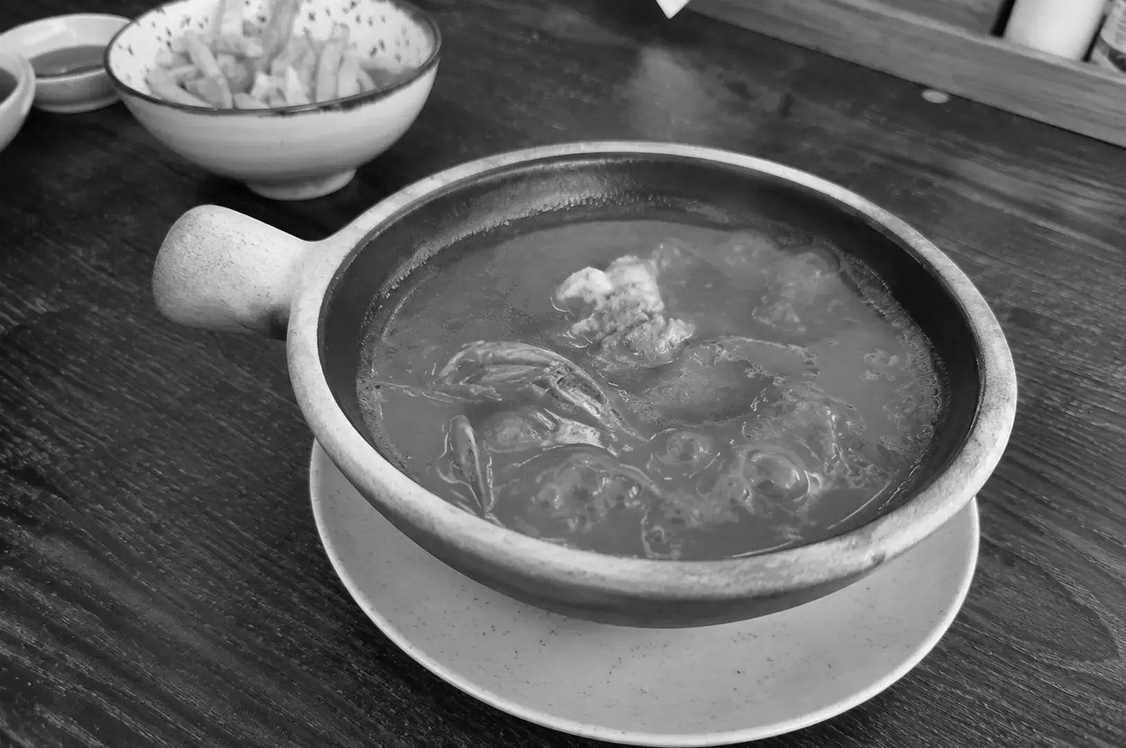 Claypot bowl of flavorful prawn soup served at a modern restaurant.