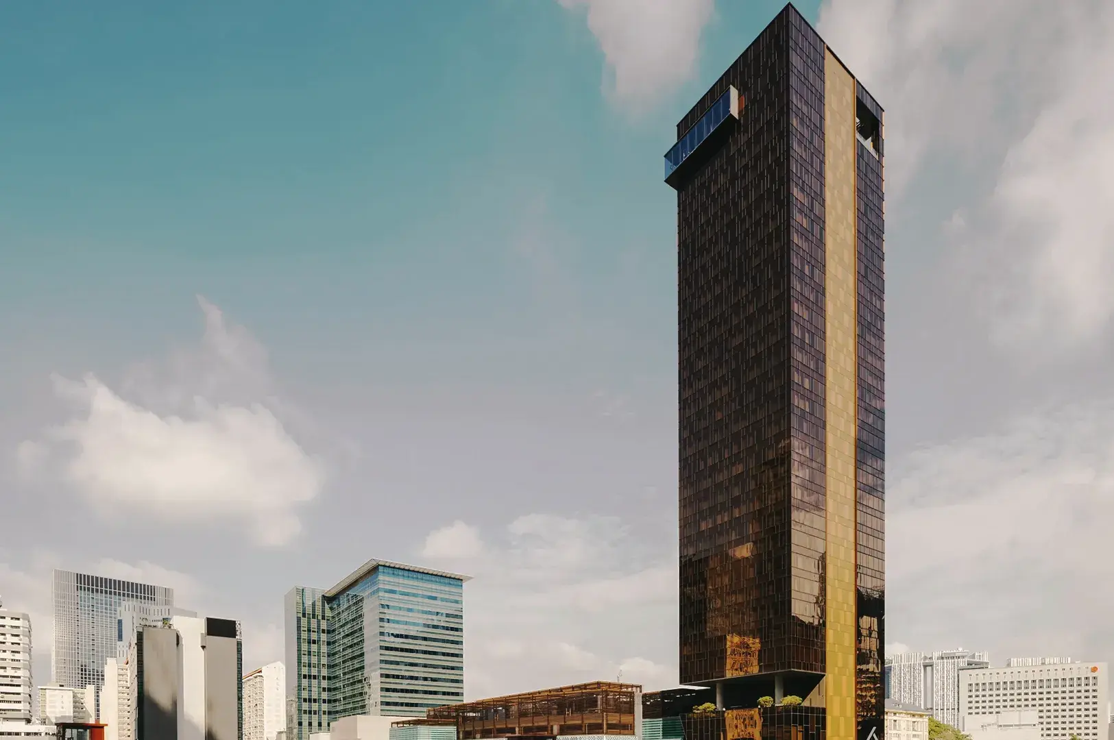 Contemporary Singapore city skyline featuring tall glass skyscraper with golden stripe and modern urban architecture.